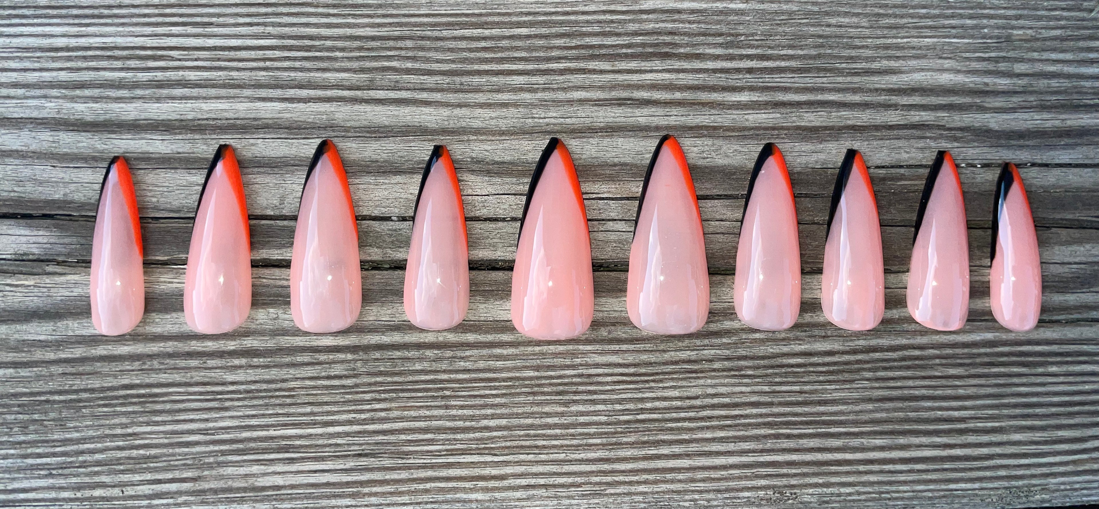 Long Weekend handmade nude press on nails with orange french tips, long stiletto