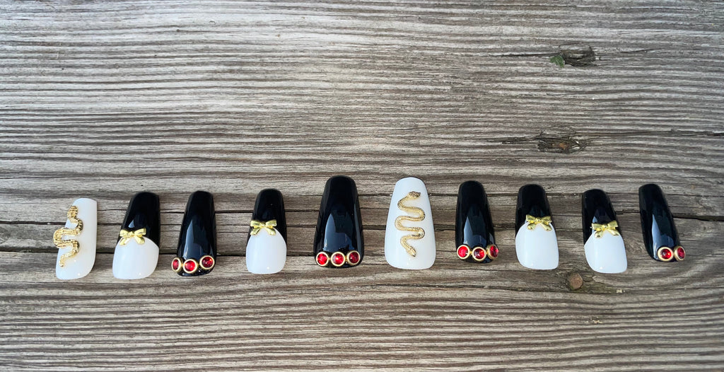 Snake Charmer handmade black french tip press on nails with gold snake charms bows and red rhinestones, medium coffin