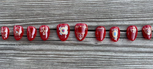 Cursed Heirloom handmade red jelly press on nails with gold filigree charms and jewels, short almond